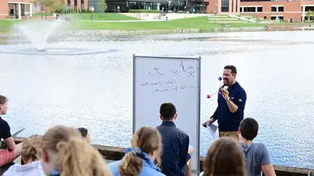 Faculty teaching a class beside the lake